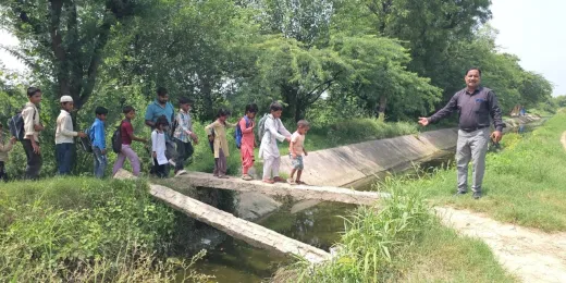 Nuh Mewat News: दो खंभों के सहारे स्कूल पहुंच रहे फलेंडी के बच्चे, प्रशासन की अनदेखी से हादसे का खतरा
