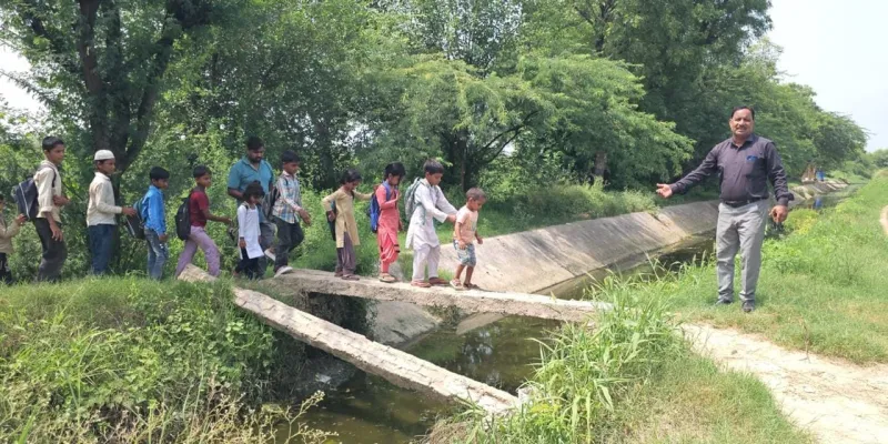 Nuh Mewat News: दो खंभों के सहारे स्कूल पहुंच रहे फलेंडी के बच्चे, प्रशासन की अनदेखी से हादसे का खतरा
