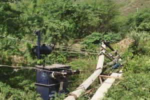 जमीन पर गिरे ट्रांसफार्मर से हो रही बिजली आपूर्ति, ग्रामीणों में दहशत